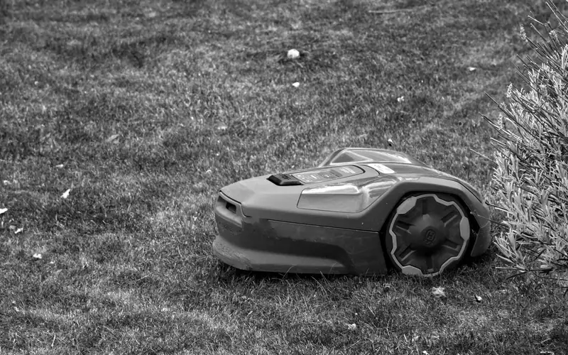 Zwart-witfoto van een robotmaaier op een gemaaid gazon